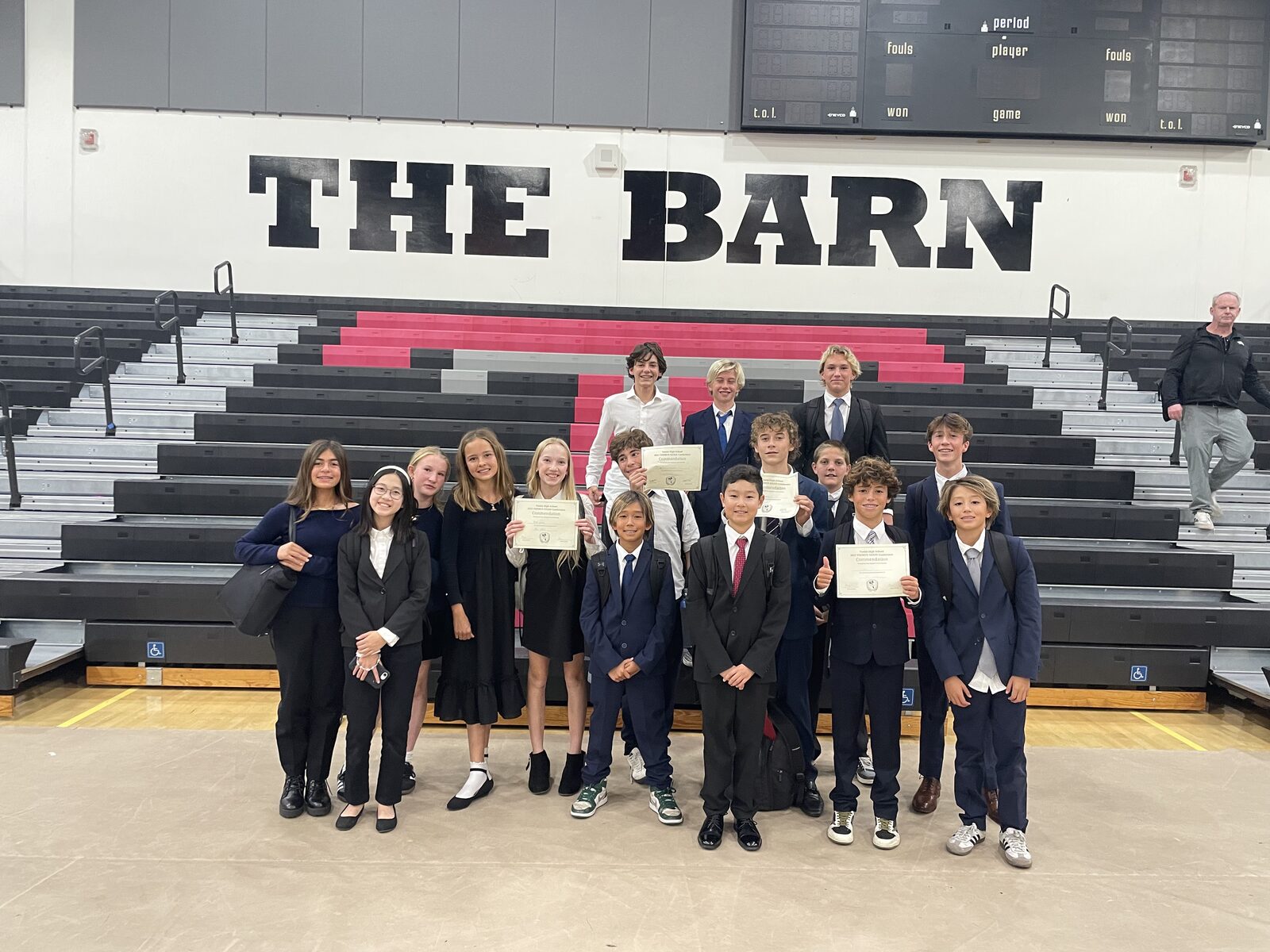 Thurston delegates holding their award certificates in the gym at Tustin High School